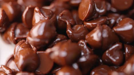 Pila-De-Chispas-De-Chocolate-Semidulce-Oscuras-Derretidas-Calientes-Que-Brillan-En-Macro-De-Luz-De-Cerca-4k-Barrido-De-Luz-Y-Pan-A-La-Izquierda