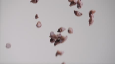 Milk-chocolate-chips-raining-down-in-slow-motion-4k-with-gray-backdrop