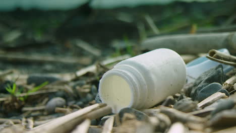 Shallow-focus-shot-of-a-bottle-lying-on-a-beach-amongst-other-rubbish