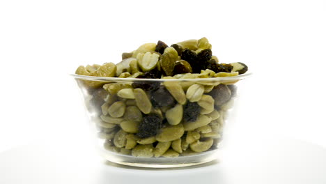 A-glass-bowl-of-mixed-nuts-rotating-clockwise-on-a-white-background