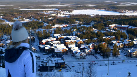 Woman-On-Ski-Holiday-Overlooking-Resort-Town,-Levi,-Finland