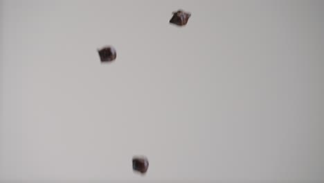 Dark-chocolate-semisweet-chips-raining-down-in-slow-motion-4k-with-gray-backdrop