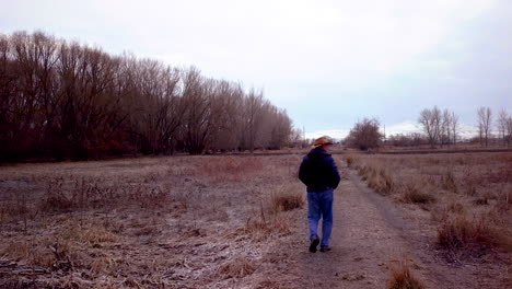 Mature-man-walks-along-a-rural-dirt-path