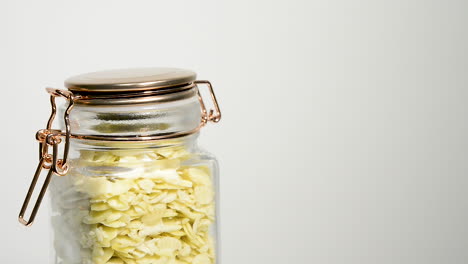 Sliced-almonds-in-an-airtight-mason-jar-rotating-on-a-white-background