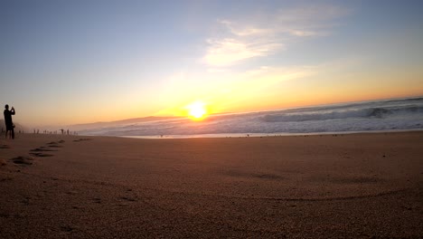 Monterey-Beach-Sonnenuntergang,-Silhouetten-Von-Menschen,-Die-Am-Strand-Spazieren-Gehen