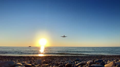 Aircraft-Landing-Over-The-Sea-At-Sunset