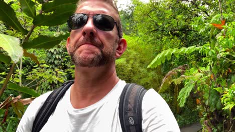 Man-walks-through-lush-green-jungle-in-Hawaii