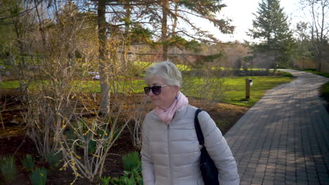 A-beautiful-senior-woman-strolls-in-a-park-alone