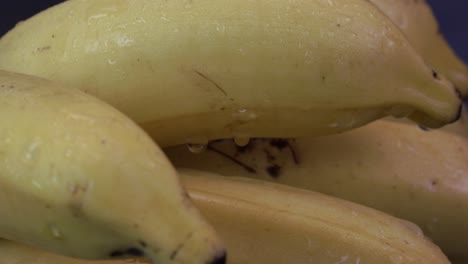 Extreme-Nahaufnahme-Von-Bananen,-Die-Mit-Wassertröpfchen-Bedeckt-Sind,-Die-Sich-Langsam-Drehen