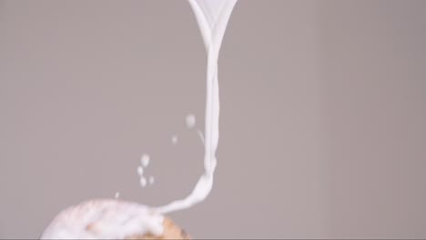chocolate-chip-cookie-flying-through-stream-of-milk-splashing-in-slow-motion-4k-with-gray-backdrop