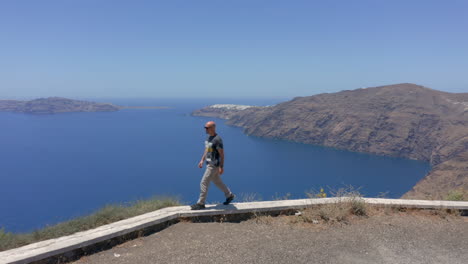 Aerial:One-man-walks-on-the-edge-of-a-cliff-in-Santorini