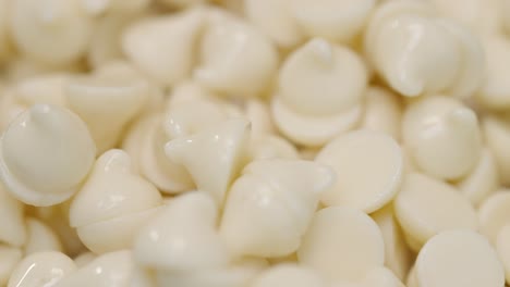 Stack-of-warm-white-chocolate-chips-glistening-in-light-macro-close-up-4k