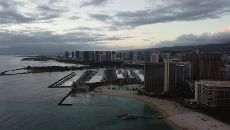Clockwise-drone-shot-of-the-beach,-marina,-and-hotels-on-the-northwest-end-of-Waikiki-during-sunset