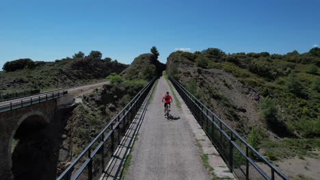 Ciclista-Cruzando-Un-Viejo-Puente-Ferroviario-En-Un-Espléndido-Día-De-Primavera-Montando-Un-Btt