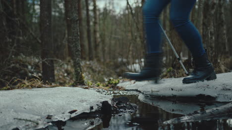 Hiker-wearing-black-high-heel-boots-jumps-over-a-puddle