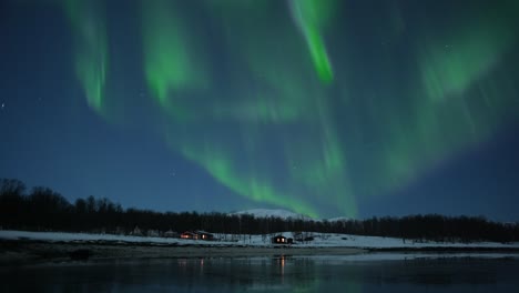winter-scenery-with-small-cozy-cabin-and-northern-lights-above-in-the-landscape-of-the-arctic-northern-norway,-timelapse,-beautiful-nature-footage