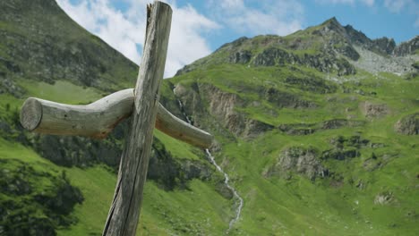 A-wooden-cross-has-been-built-near-a-little-church-in-Gressoney,-in-Italy,-in-front-of-Monte-Rosa-and-other-beautiful-mountains