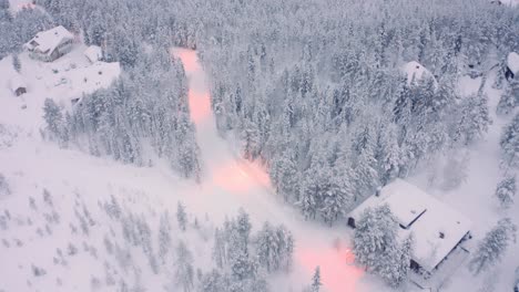 Snowy-pine-forest-with-roads-and-cabins,-taiga-tundra-Finland-neighborhood-pull-back-tilt-down-drone-aerials