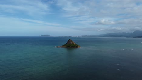 4K-cinematic-crane-drone-shot-of-Chinaman's-Hat-in-Oahu-surrounded-by-calm-crystal-clear-ocean-water