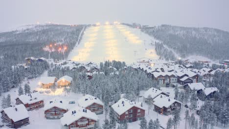 Drone-aerial-pull-back,-Levi-ski-resort-snowy-ski-village-in-Finland