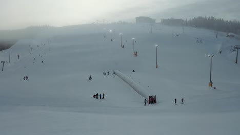 Aerial-drone-Levi-ski-resort-in-the-fog,-pulling-back-away-base-area