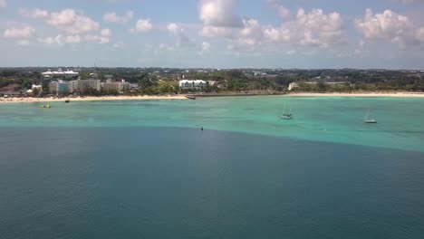 Aerial-view-towards-the-coastline-of-sunny-Nassau,-Bahamas---rising,-drone-shot