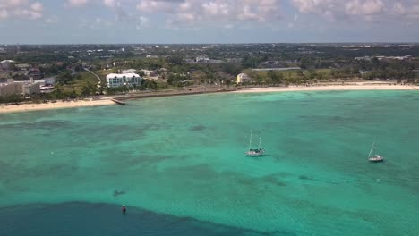 Aerial-view-overlooking-sailboats-on-the-coastline-of-Nassau,-Bahamas---pan,-drone-shot