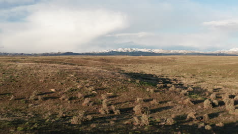 Low-flying-over-vast-Idaho-plain-toward-snow-capped-mountains-in-rural-Idaho