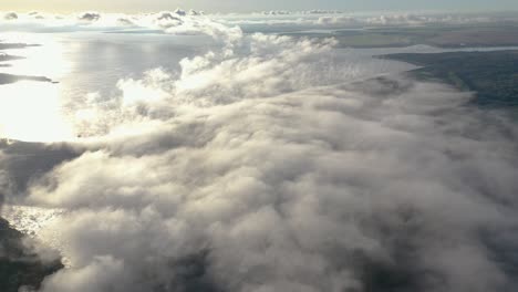 Aerial-view-of-clouds-over-hydroelectric-power-plant-pond,-fog-at-dawn