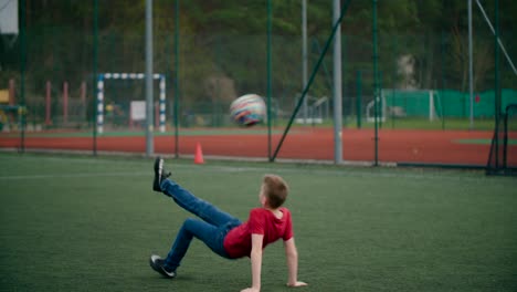 Junge-Springt-Und-Schießt-Den-Ball-Auf-Das-Feld