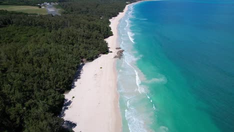 Aerial-footage-along-white-sand-beach-with-calm-turquoise-waters-on-Oahu,-Hawaii
