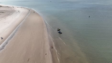 Eine-Luftaufnahme-über-Den-Strand-Von-Gravesend-Bay-In-Brooklyn,-New-York,-Während-Sich-Zwei-Jet-Ski-Fahrer-Auf-Die-Fahrt-Vorbereiten