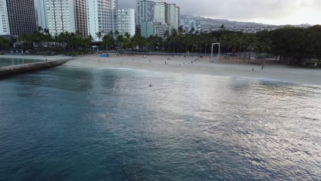 4k-Filmische-Drohnenaufnahme,-Die-Waikiki-Beach-Und-Hotels-Vom-Blauen-Ozean-Bei-Sonnenaufgang-In-Oahu-Zeigt