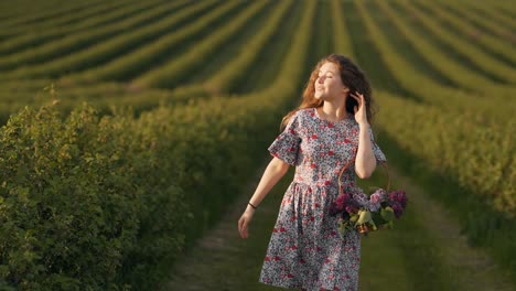 Beautiful-curly-red-haired-girl-in-a-field-with-a-basket-of-lilac-flowers