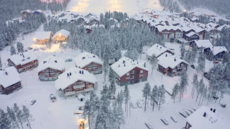 Drone-aerial-tilt-up-onto-ski-lodges,-hotels,-slopes,-Levi,-Finland-ski-resort