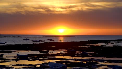 Unglaubliche-Sonnenuntergangslandschaft-Mit-Tief-Stehender-Sonne-Und-Silhouettenfischerbooten-Bei-Ebbe