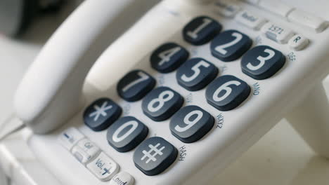 Close-up-of-a-A-man-dialling-999-on-a-landline-telephone