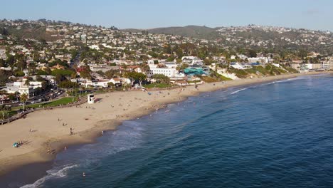 Aerial-view-of-people-enjoying-a-sunny-day-at-Laguna-beach,-in-California,-USA---tracking,-drone-shot