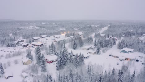 Levi,-Finland-village-snowy-neighborhood-pine-trees-for-miles,-Drone-aerial-flyover,-taiga-tundra