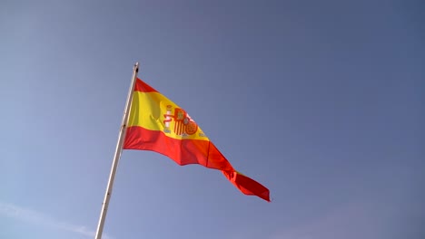 Bunte-Spanische-Flagge,-Die-In-Zeitlupe-Gegen-Den-Blauen-Himmel-Weht