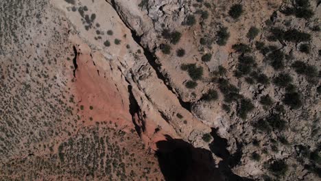 Awesome-aerial-view-of-the-edge-of-a-cliff-in-a-red-dessert-canyon-in-Villaspesa,-Teruel