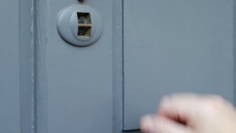 A-man-knocking-on-a-grey-wooden-door