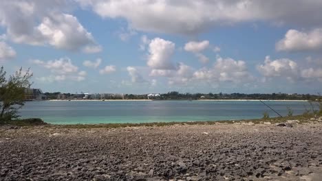Luftaufnahme-über-Einen-Strand-Und-Türkisfarbenes-Wasser,-In-Richtung-Der-Küste-Von-Nassau,-Bahamas---Niedrig,-Drohnenaufnahme