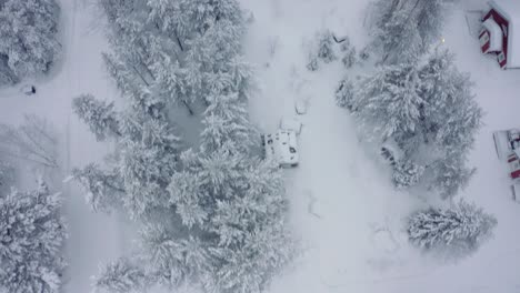 Drohne-Antenne-Nach-Oben-Kippen,-Levi-Ski-Resort-Schneebedecktes-Skidorf-In-Finnland-Mit-Fußgängern-Und-Arbeitern-Im-Lebensmittelgeschäft,-Die-Schnee-Räumen