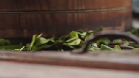 Grüne-Teeblätter-Gerollt-In-Alten-Chinesischen-Walzmaschinen