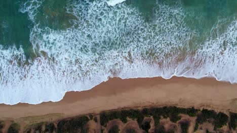Vertical-static-drone-footage-of-waves-hitting-the-beach-at-Point-Lonsdale,-Victoria,-Australia