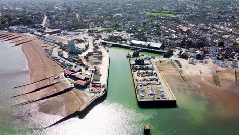 A-dolly-backwards-aerial-view-of-Whitstable-Harbour,-with-a-calm-sea