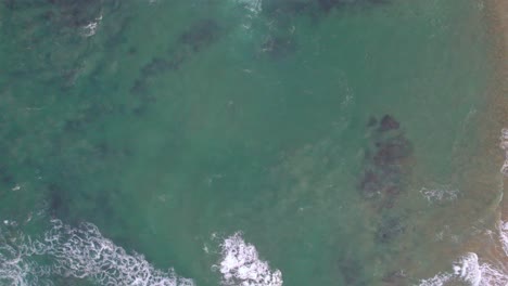 Vertical-slow-moving-drone-footage-of-waves-along-te-coast-at-Point-Lonsdale,-Victoria,-Australia