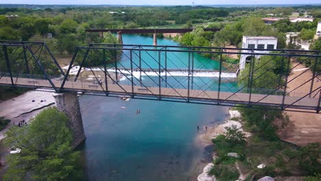 Drone-footage-of-the-historic-Faust-Street-bridge-in-New-Braunfels,-Texas-that-goes-over-the-Guadalupe-River-near-Interstate-35