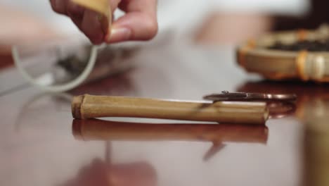 Aufnehmen-Des-Teeblatthalters-Vom-Kleinen-Bambusständer-Auf-Dem-Traditionellen-Hölzernen-Teetisch